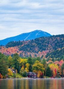 A beautiful autumn landscape of Mirror Lake, surrounded by vibrant fall foliage in the Adirondacks.